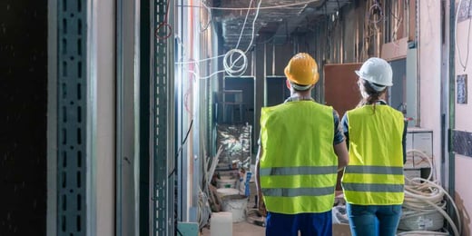 Two people in reflective jackets at a construction site