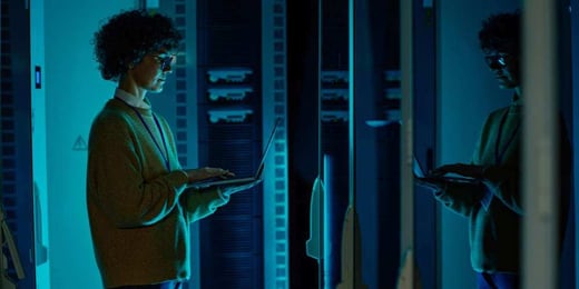 Person working on a laptop in a data centre