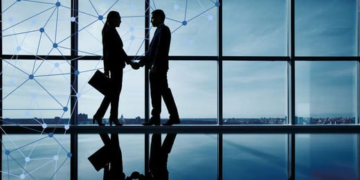Business leaders shaking hands in a modern office, symbolising strategic partnerships in the digital and AI economy.